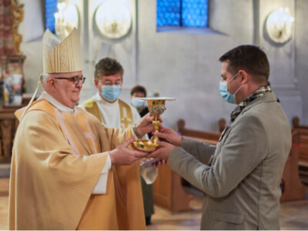 (Photo: Michel Monnerat reçoit l’institution pour le service de l’Eucharistie).
