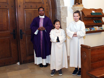 L'abbé Jean-René Malaba avec les servantes de messe: Lucie Rais, des Enfers, et Mélissa Tschudi, de Montfaucon