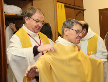 Dans la sacristie, l'abbé Jean-Marie Nusbaume ajuste la chasuble de Mgr Gilbert Louis